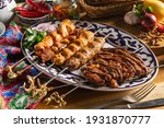 Platter of kebabs. Uch-panzha of lamb, kebab chicken kebab with lamb, a shish kebab of chicken and lamb skewers on a plate with traditional Uzbekistan ornament.