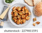 Croutons with herbs, garlic and cheese from white bread or baguette. Served for salad or soup. Selective focus, top view