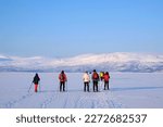Small photo of Silhouettes of tourists on snowshoes on lake Tornetrask (Tornestrask) around Abisko National Park (Abisko nationalpark) in winter scenery. Sweden, Arctic Circle, Swedish Lapland