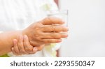 Small photo of close up senior woman hand hold glass of waster for drink with unsteady at home for mature lifestyle and Parkinson's symptom concept
