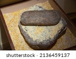 Small photo of LOS ALAMOS, NEW MEXICO - DECEMBER 13, 2013: Maize corns, being ground on an ancestral Pueblo Indian millstone, inside the Los Alamos Historical Museum.