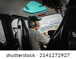 Man sitting in helicopter cabin while flying over Italian Alps