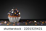 Small photo of Cupcake on Halloween. Dessert on Halloween party. Muffin decorated with colored sprinkles, black frosting, icing. Cupcake on dark background. Macro high quality and resolution photo. Copy space