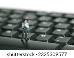 Small photo of Miniature tiny people toy figure photography. A businessman getting ready, justify the tie standing above keyboard. Isolated on white background