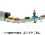 Miniature tiny people toy figure photography. A businessman standing waiting for his baggage at the airport. Isolated on a white background. Image photo