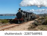 Small photo of VICTOR HARBOR, SOUTH AUSTRALIA, AUSTRALIA - APRIL 10, 2023 : The Cockle Train driven by Engine RX 224, a 1915 built steam locomotive, travels along the coastal railway adjacent to Encounter Bay.