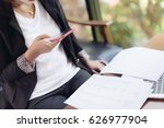 Small photo of Asian female accountant or banker is busy working with laptop, smart phone and document in home office in selective focus. Concept : Busywork