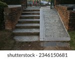 Small photo of Steps, a staircase with handrails, railings, descent and ascent for people with disabilities and prams, bicycles. Made from stone cemented. Brick wall on the side.
