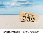 Closed sign on tropical sand beach with blue sky background. Summer vacation and travel holiday concept. Vintage tone fitler effect color style.
