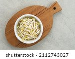 Fresh bean sprouts or tauge ready to cook served in small bowl on grey background. Selected focus.