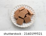 Small photo of Square wafer biscuits, crunchy wafers with chocolate cream flavor. Served in plate, close up.