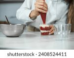 Small photo of Process of creating red velvet trifle. Confectioner at work