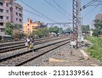 Small photo of West Bengal, 02-13-2022: Two young girls are walking across train lines instead of using railway foot bridge (this type of carelessness and absent-mindedness often causes accident).