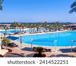 Pool at the beach of a luxury hotel in Sharm El Sheikh. Tiran Island is visible in the background. Egypt, Sinai Peninsula. Design for postcard or calendar, concept of rest and relaxation.