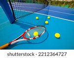 Tennis racket and tennis ball  on hard blue court