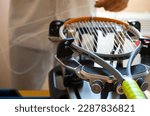 close-up of the hands of a master who pulls the strings on a tennis racket using a special machine