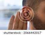 Small photo of Tinnitus. Young man with hearing problems or hearing loss. Hearing test concept.