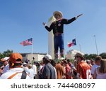 Small photo of DALLAS, TEXAS—OCTOBER 2017: People mill around the Big Tex statue who speaks and waves his hands to welcome visitors to the State Fair of Texas carnival grounds in Dallas.