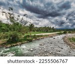 Small photo of The beauty of kabacan river in Magpet, North Cotabato Philippines. with a dark sky and green tropical vegetation.