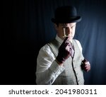 Small photo of Portrait of Man in Bowler Hat and Tweed Vest Holding a Sharp Knife on Black Background. Old-Fashioned Ruffian or Rogue. Uncouth Cad and Notorious Criminal