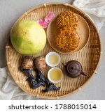 Small photo of Popular snacks and food eaten during mid autumn festival / Mooncake, Chinese Tea,Taro, Water Caltrop and Pomelo / The chinese characters translates as double egg yolk lotus paste and red bean paste