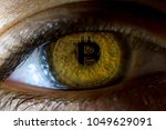 Crypto currency Gold Bitcoin, BTC, Bit Coin. Macro shot of Bitcoin. Eye of a person with the bitcoin coin reflected in the pupil. Blockchain technology, bitcoin mining concept
