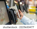 Closeup Woman Counter Buy electronic payment supermarket smartphone Female hand with a mobile phone in pay for purchases in stores Contactless NFC Terminal Closeup card reader.