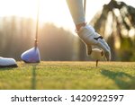 Small photo of hand of woman golf player gentle put a golf ball onto wooden tee on the tee off, to make ready hit away from tee off to the fairway ahead. Healthy and Lifestyle Concept.
