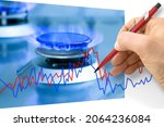 Small photo of Increased costs about methane, propane and butane gas - concept with detail of a burner of a domestic methane or propane gas cooker and chart
