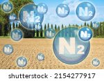 N2 nitrogen gas is the main constituent of the earth's atmosphere - concept with nitrogen molecules against a natural rural scene