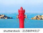 Small photo of An improbable hydrant at the seaside - Plenty of water concept with an hydrant against a seascape