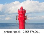 Small photo of An improbable hydrant at the seaside - Plenty of water concept image with red hydrant against ocean