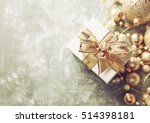 Christmas Present with Gold Ribbon and Gold Christmas Decorations. Rustic Background. Christmas background. Top view. Copy space.