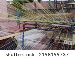 Small photo of colored linen warp threads on a weaving machine.