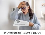 Woman is shocked from the rising energy costs and the bill she received for heat and electricity for her household.