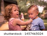 Small photo of Children at birthday party, little adorable girl generously sharing her drink with cute child friend, letting him taste it, from a birthday cup with stars, using a straw. Restoring faith in humanity.