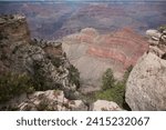 Small photo of A panorama of the grand canyon from the southern viewpoint showing the gorge and the strata of coral pink and cream stone as far as the eye can see on a beautiful summers day.