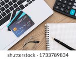 Small photo of Computer laptop, credit cards, calculater, notbook pen and glasses on the desk, account and saving concept.