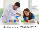 Small photo of male and female students Have fun mixing colorful liquids in a glass tube. Science lab chemistry test. Concepts. Observational physics. learn in the classroom and science experiments and research.