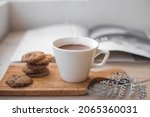 A cup of hot chocolate and cookies on wooden tray for winter background