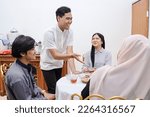 Small photo of Young asian muslim people chit chat while dinner break fasting together at home during ramadan
