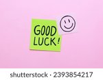 Sticky note with Good Luck handwriting on pink background.