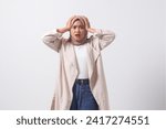 Small photo of Portrait of frightened Asian hijab woman in casual suit holding head, showing surprised and scared expression. Isolated image on white background