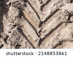 Small photo of Footprint of wheel tread on the ground road. The trail from the tread of trucks wheels. Car tire tread imprint on sand, background, texture. Footprints rubber tyres from automobile. Close-up