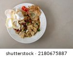 Small photo of Kupat Tahu Magelang, Flat Lay with negatif space photo. It is a traditional Indonesian food made from fried ketupat, tofu, cabbage and bean sprouts, mixed with peanut sauce and soy sauce.