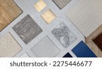 Small photo of creative composition of interior material samples contains panels and tiles. stylish interior moodboard including terrazzo, quartz, stone tiles, blue laminated, wooden flooring tiles, gold stainless.