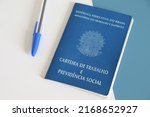 Small photo of Bahia, Brazil - June 16, 2022: Translation: Work record booklet and Social Welfare. Brazilian work card (carteira de trabalho) on office desk. Brazilian pension system. Retirement concept.