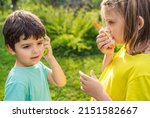 Small photo of Small kids,girls play in walkie-talkie.Walkie Talkies with channels.Game of detectives, spies.Children talk,say messages at distance.Communication with parents in forest,park,hike.Finding lost people.