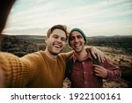 Small photo of Caucasian male friends hiking in wilderness taking selfie with cellular device embracing the outdoors