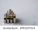Screwdriver bits, electric screwdriver, different designs on grey background. Copy space.